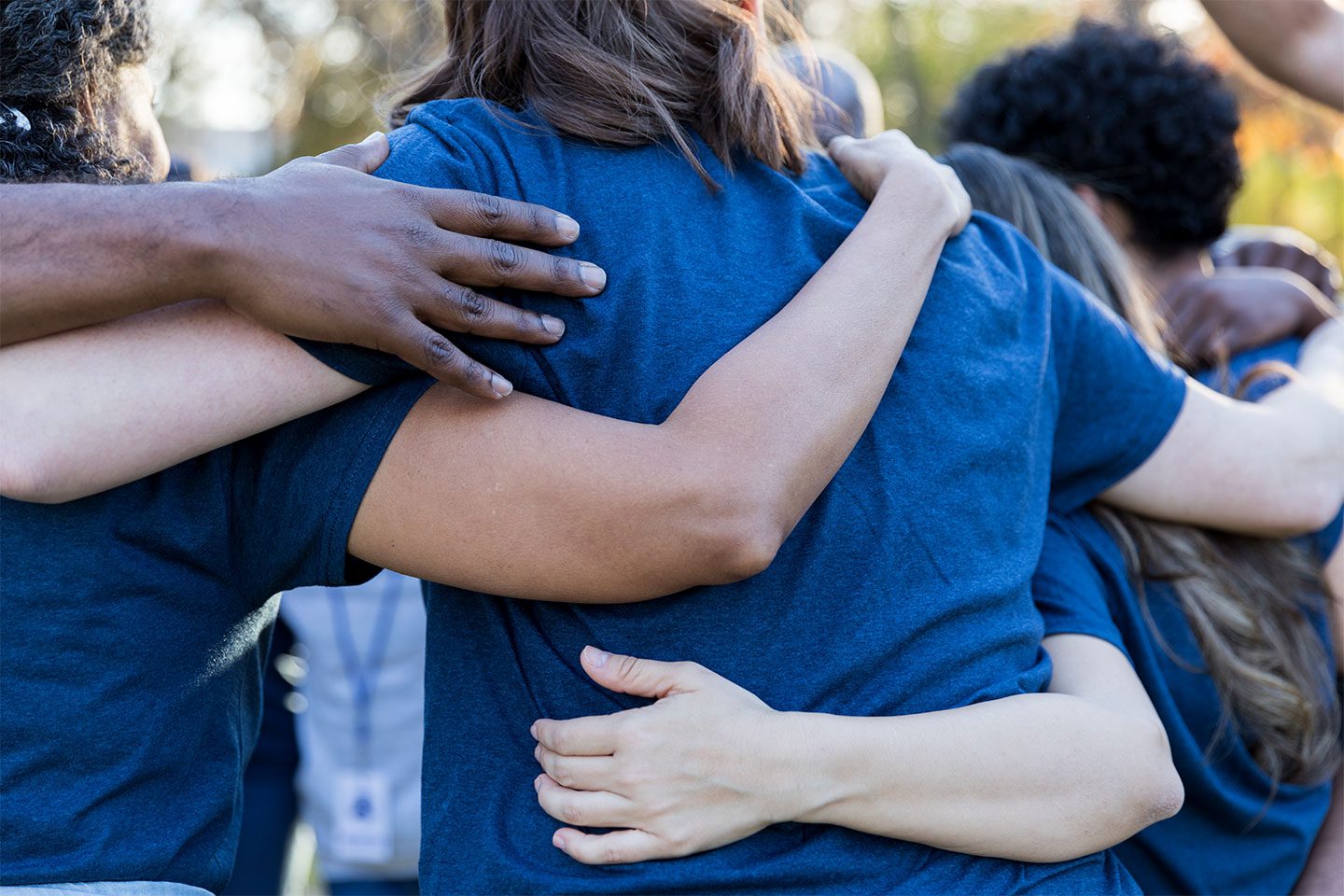 group of people with arms around each others back